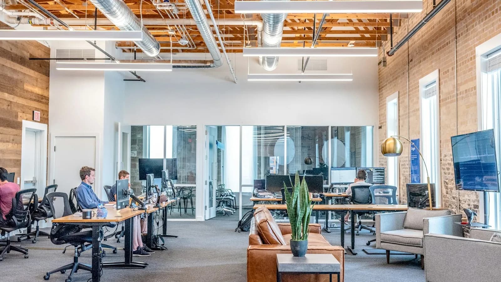Modern London LSCT office lounge with leather sofas and exposed brick walls